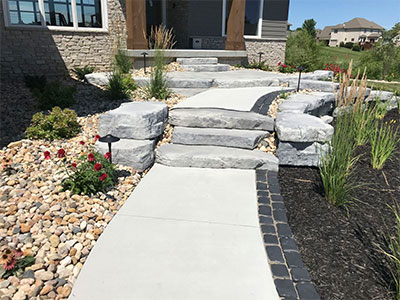 Landscape lighting on a custom stone walkway in residential landscaping